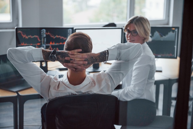 Talking to each other. Two stockbrokers in formal clothes have a break in the office.