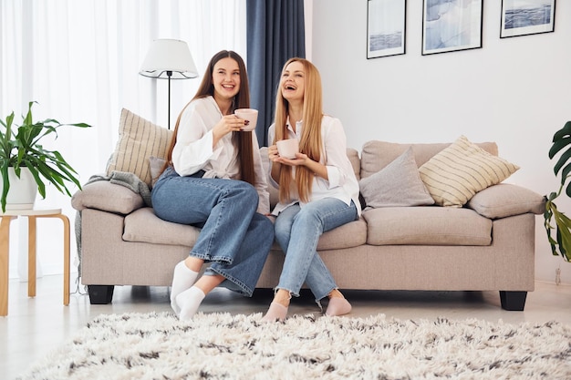 Photo talking to each other young mother with her daughter is at home at daytime