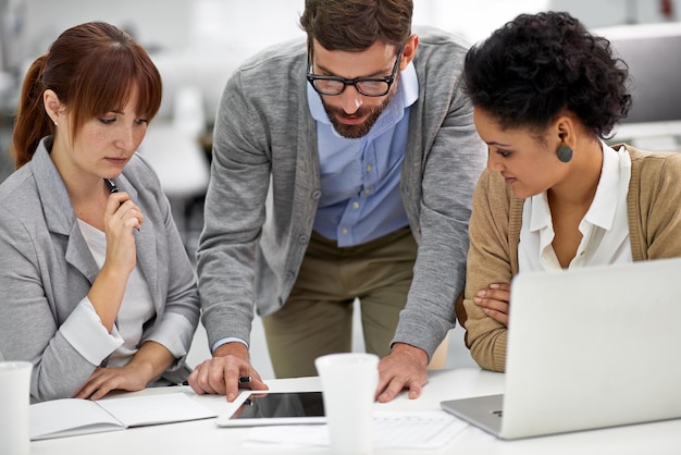 Parlare con i suoi colleghi attraverso il progetto. inquadratura di un gruppo di giovani professionisti dell'ufficio che parlano su una tavoletta digitale.