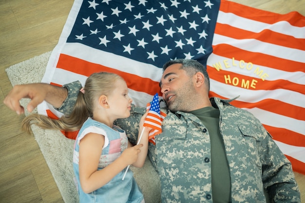 Фото Разговаривает с дочерью. счастливый героический военнослужащий трогательно разговаривает со своей маленькой дочерью