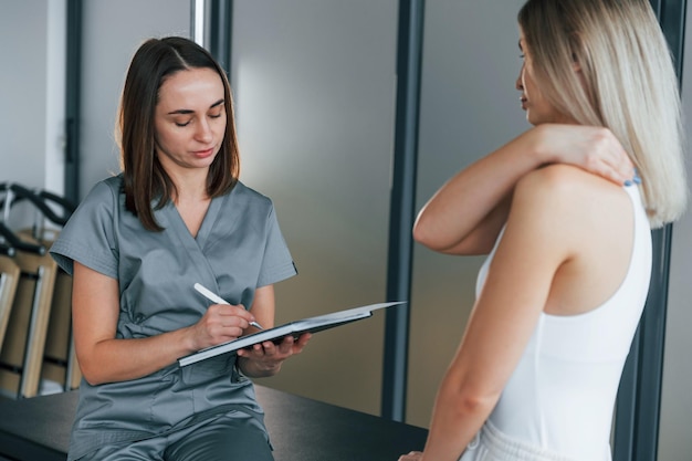 Talking with each other woman is in health center getting help\
by doctor