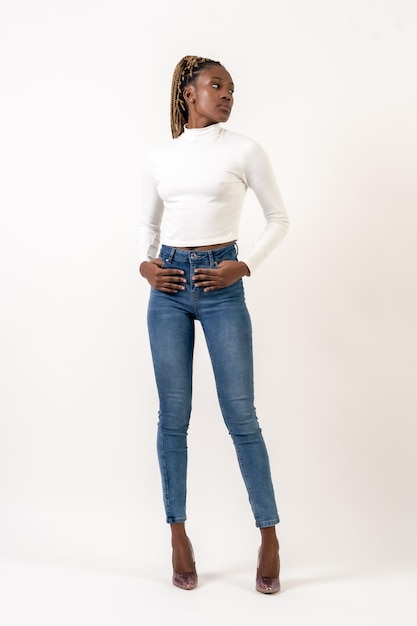 Tall black ethnic woman with braids studio portrait on a white background looking sideways