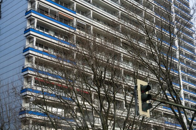 A tall building with blue and white stripes and a traffic light in front of it