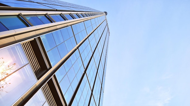 a tall glass building with a blue sky in the background