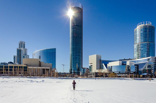 Tall houses in winter near a frozen lake.