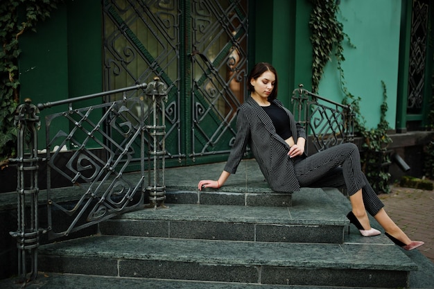 Photo a tall leggy young beautiful and elegant model woman at formal wear posed on stairs