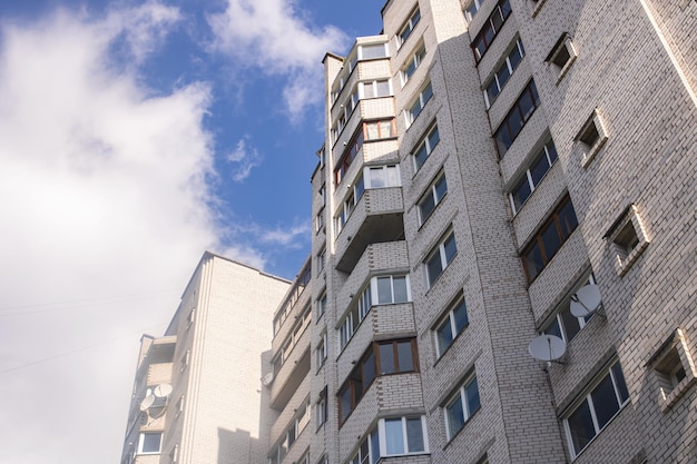 Tall residential building on background of blue sky bottom view