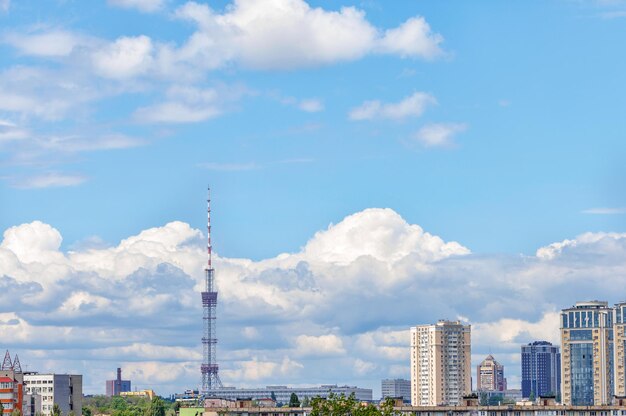 A tall tv tower against a blue sky in an urban summer landscape