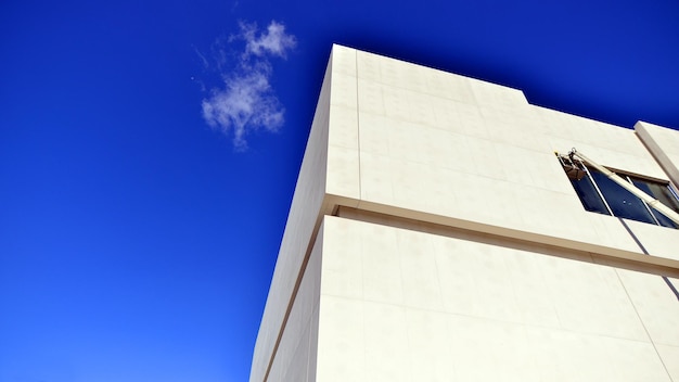 a tall white building with a cloud in the sky