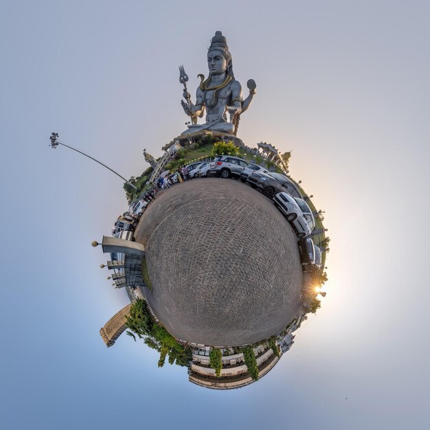 Photo tallest hindu shiva statue in india on mountain near ocean on little planet in blue sky transformation of spherical 360 panorama spherical abstract view with curvature of space