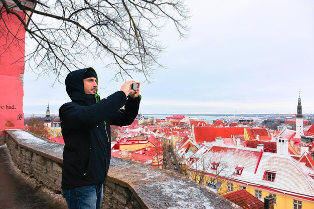 Tallinn, Estland - 27 februari 2017: Man met camera fotograferen van stadsgezicht van de oude stad van Tallinn, Estland in de winter. Uitzicht vanaf de Toompea-heuvel