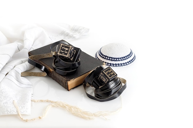 タリットとテフィリンと白い背景の上のユダヤ人のキッパー ヤムルク帽子