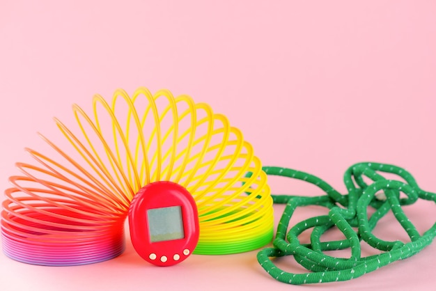 Photo tamagotchi game virtual pet with rainbow and rubber band on a pink background