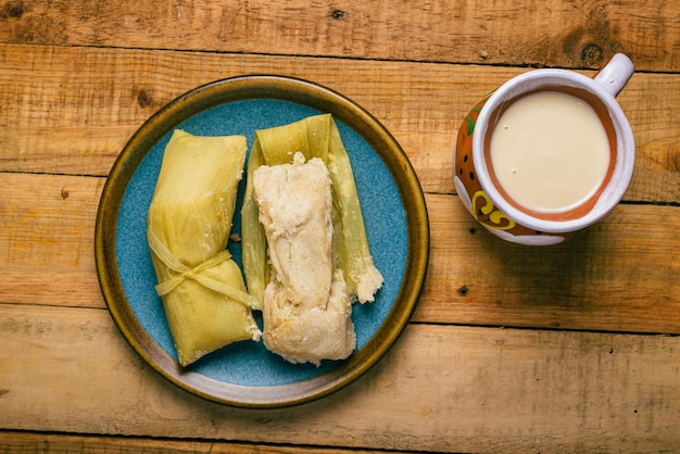 Photo tamales de elote and atole on a wooden table typical mexican food