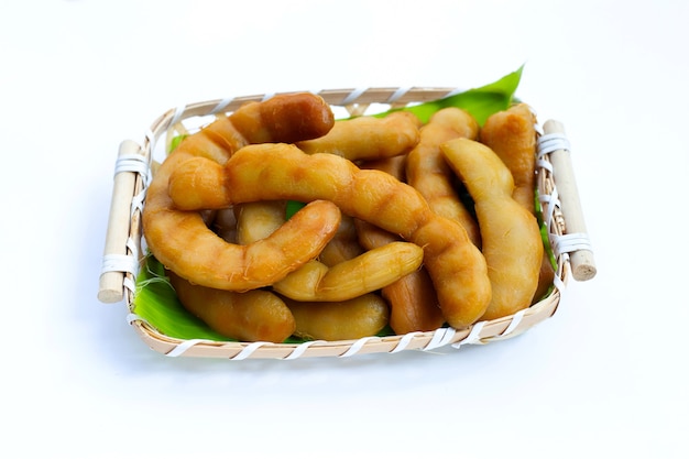 Tamarind pickled fermented in bamboo basket on white background.