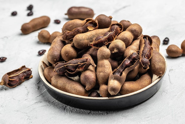 Tamarinds beans in shell on a brown butchers block on a light background healthy fruit banner menu recipe place for text top view