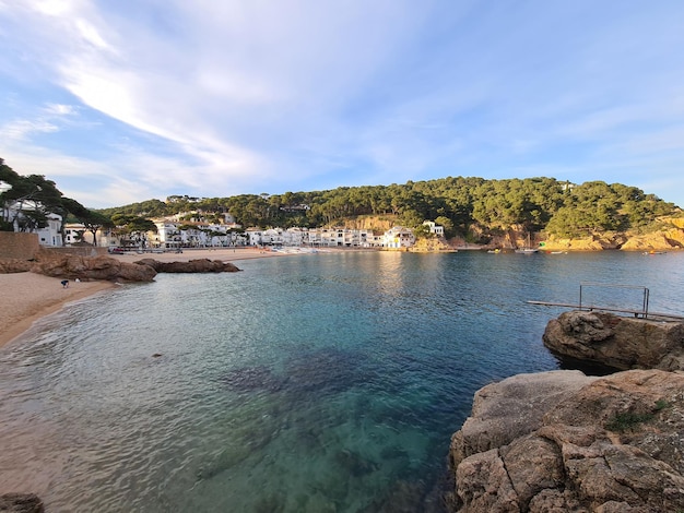 Tamariu 1 coastal town with clear water and rock formations white houses pine trees and a swim board