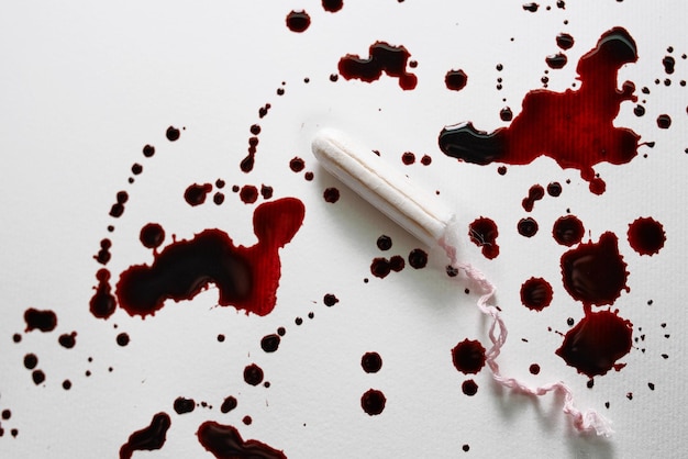 tampon on white and bloody background. Health care, hygiene, feminine concept