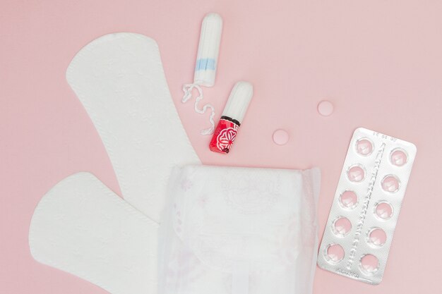 Tampons and pads on a pink background