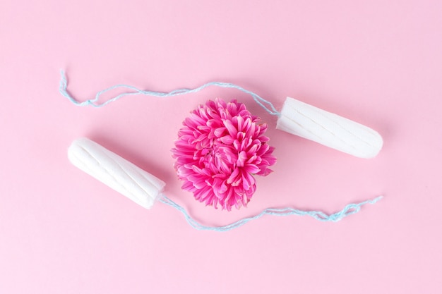 Tamponi e un fiore rosa. cura dell'igiene nei giorni critici. ciclo mestruale