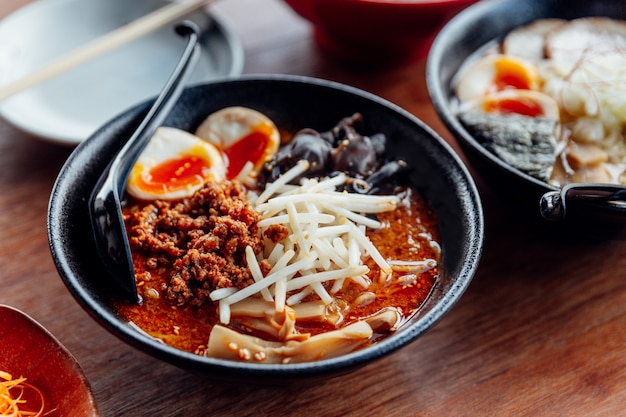 Tan tan ramen: japanse noedel in tan tan-soep met gehakt varkensvlees, gekookt ei, houtoor.