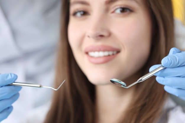 Tandarts arts met tandheelkundige instrumenten voor vrouwelijke patiënt in kliniek close-up