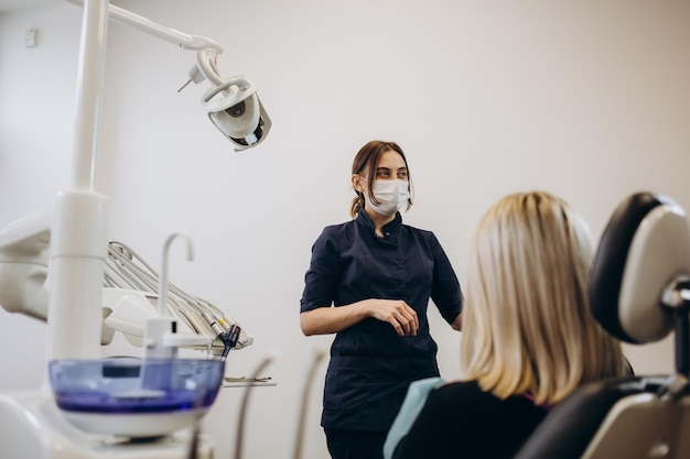 Tandarts die de tanden van de patiënt onderzoekt in de moderne kliniek Cosmetische tandheelkunde