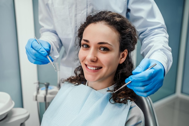 Tandarts die de tanden van een patiënt in de tandartsstoel onderzoekt Gezondheidszorg en geneeskundeconcept