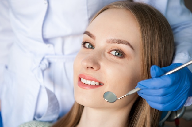 Tandarts die de tanden van een patiënt in de tandkliniek onderzoeken.
