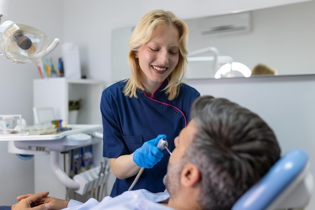 Foto tandarts die de tanden van een patiënt in het kantoor van de tandarts onderzoekt man-patiënt met tandheelkundige behandeling in het kantoor van de tandarts