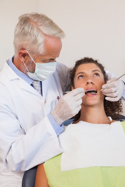 Tandarts die een patiëntentanden onderzoeken als tandartsenvoorzitter