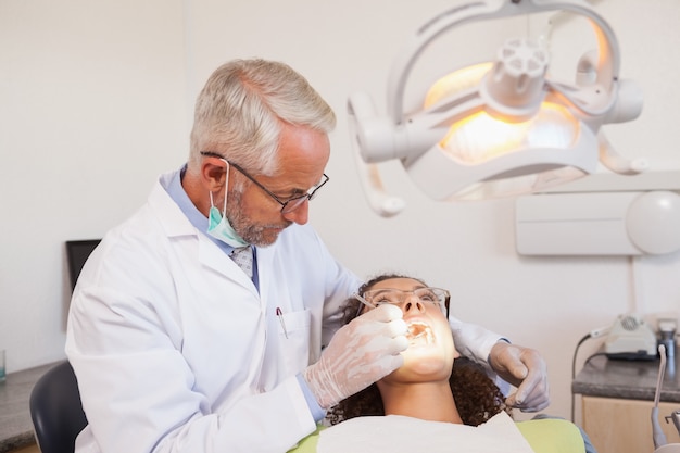 Tandarts die een patiëntentanden onderzoeken als tandartsenvoorzitter
