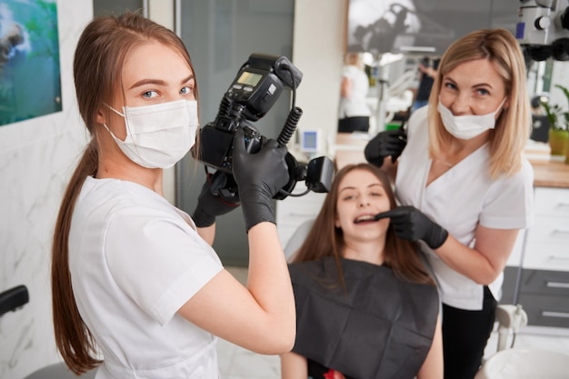 Tandarts die foto neemt van vrouwelijke patiënt in tandartspraktijk