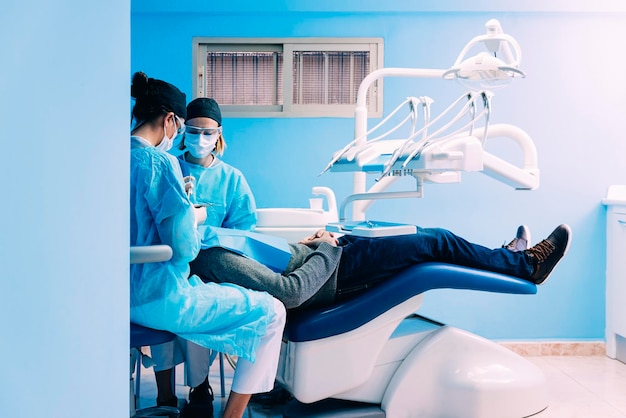 Tandarts die patiënt in de kliniek onderzoekt