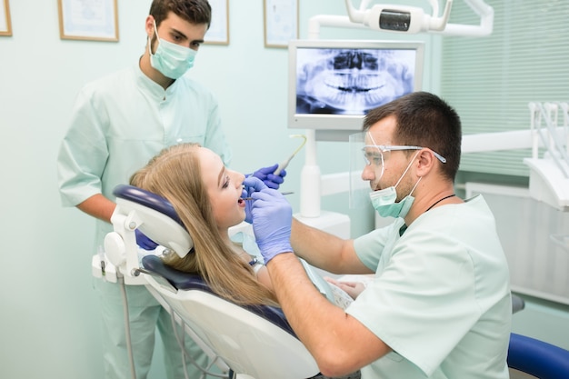 Tandarts die procedure met tand het genezen UVlicht in kliniek doet