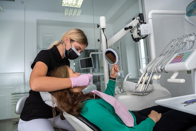Tandarts die procedurepatiënt in tandartsbureau doet. gezondheidszorg concept