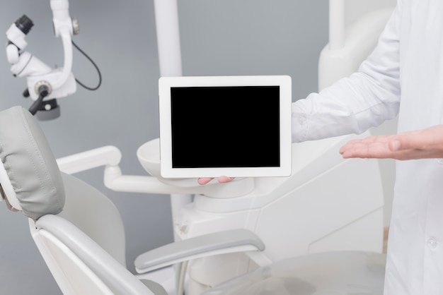 Foto tandarts die tablet voorstelt