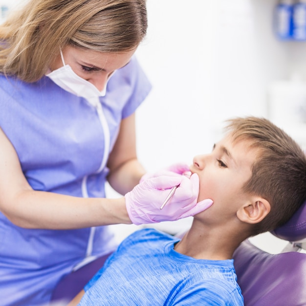 Tandarts die tanden van een jongen in kliniek controleert