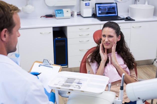 Foto tandarts in gesprek met vrouwelijke patiënt