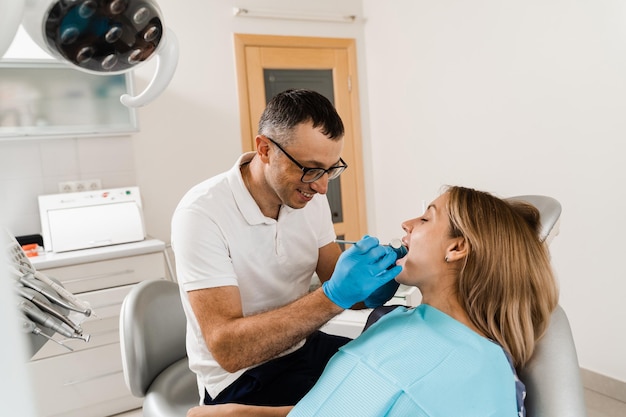 Tandarts onderzoekt tanden van vrouw voor behandeling van kiespijn Pijn in tanden Overleg met tandarts in de tandheelkunde