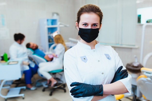 Tandarts. portret van een professionele tandarts op de achtergrond van een werkend team van artsen. concept van medisch onderwijs en medische verzekering.