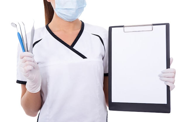 tandarts, vrouw, in, masker, vasthouden, gereedschap, en, klembord, met, blanco, papier, geïsoleerde, op wit, background
