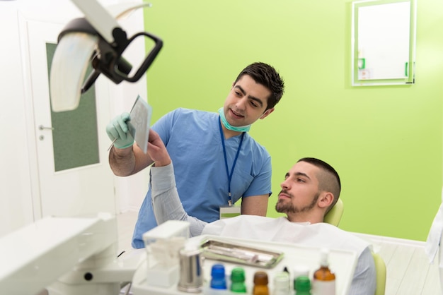 Tandartsassistent en patiënt kijken naar tand XRay