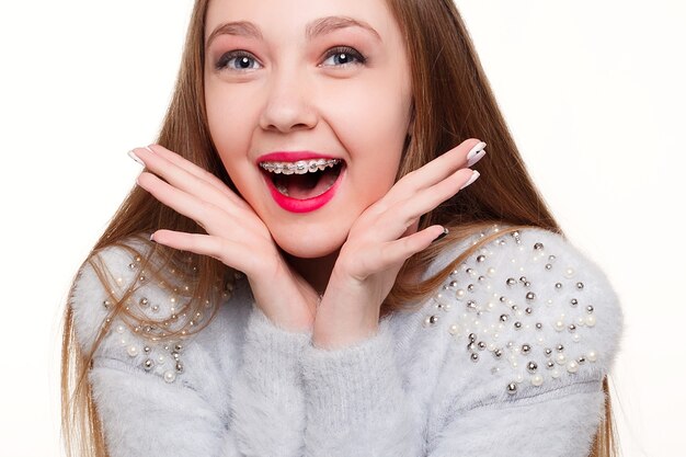 Tanden, emoties, gezondheid, mensen, tandarts en lifestyle concept - Gezonde, mooie glimlach, het kind naar de tandarts. Portret van een klein meisje met orthodontische apparatuur.