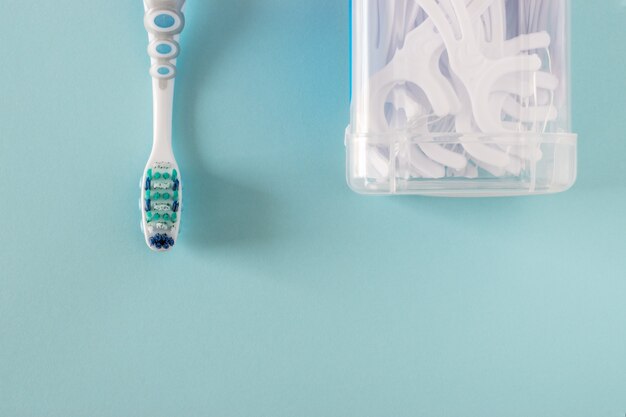 Tandenborstel en tandzijde op helderblauwe achtergrond