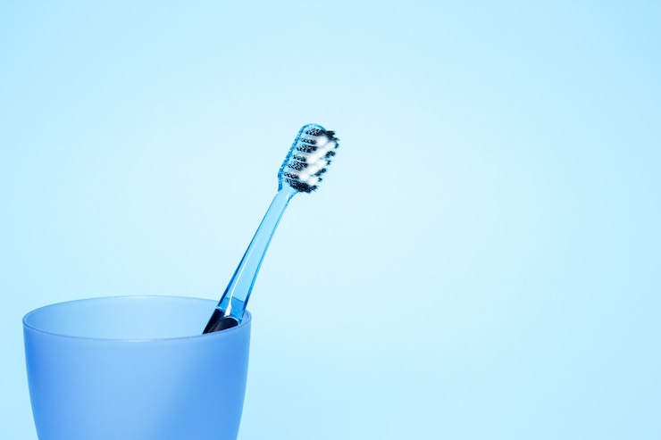 Foto tandenborstel in een glas op blauwe achtergrond