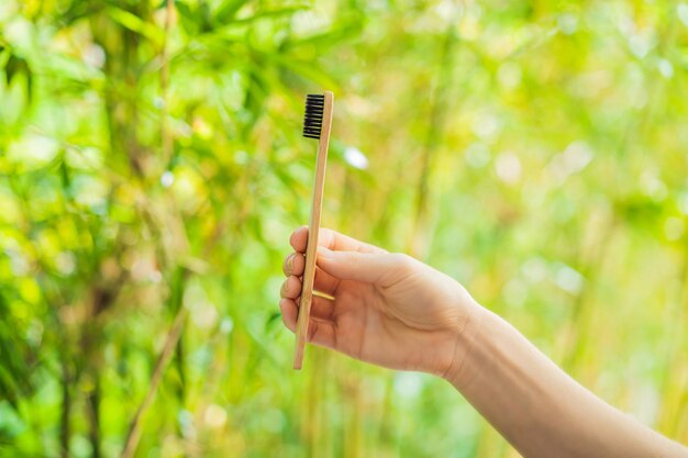 Tandenborstel van bamboe op een achtergrond van groen groeiend bamboe