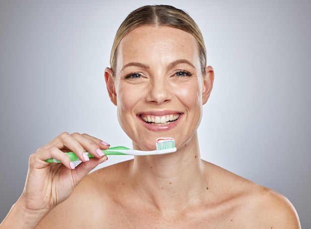 Tandenpoetsen en glimlachen met portret van een vrouw voor het bleken van schoonheid en ochtendroutine Reiniging van mondhygiëne en fluoride met gezicht van model en tandpasta voor gezondheid en tandverzorging