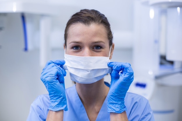 Tandheelkundige assistent chirurgische masker dragen in tandheelkundige kliniek