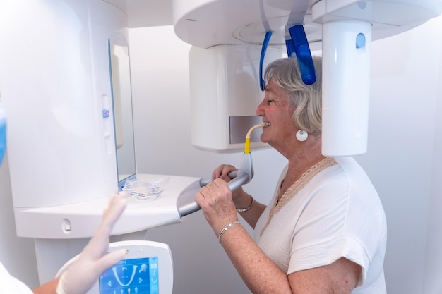 Tandheelkundige kliniek oudere vrouw in de röntgenkamer die een röntgenfoto uitvoert